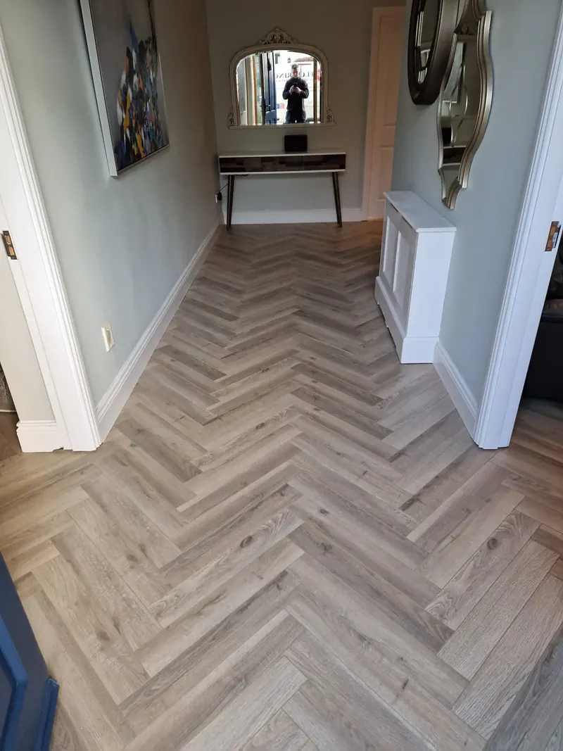 Pale herringbone floor in a bright entrance hallway