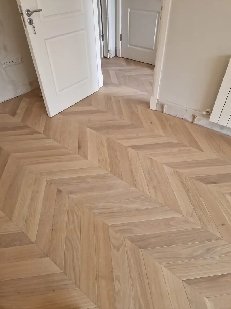 Light chevron floor through a hallway and doorway