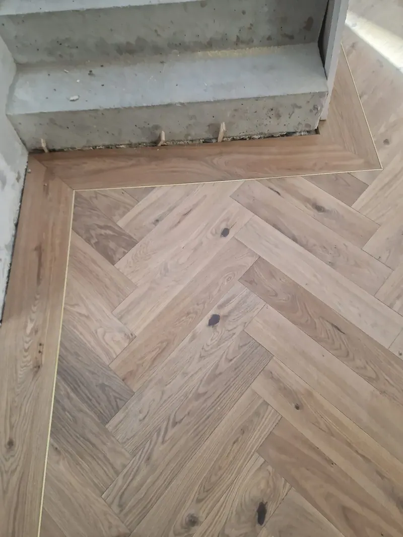 Herringbone being laid on a prepared subfloor at a doorway
