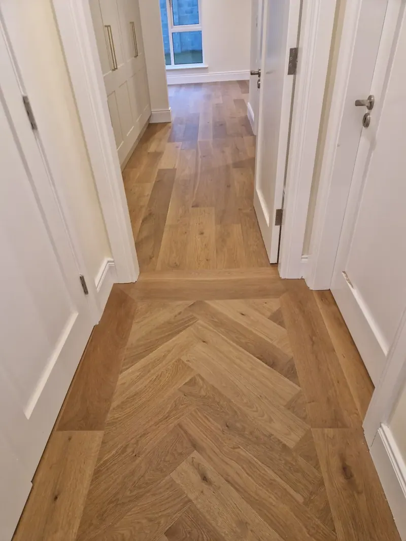 Warm-toned herringbone running the length of a hallway