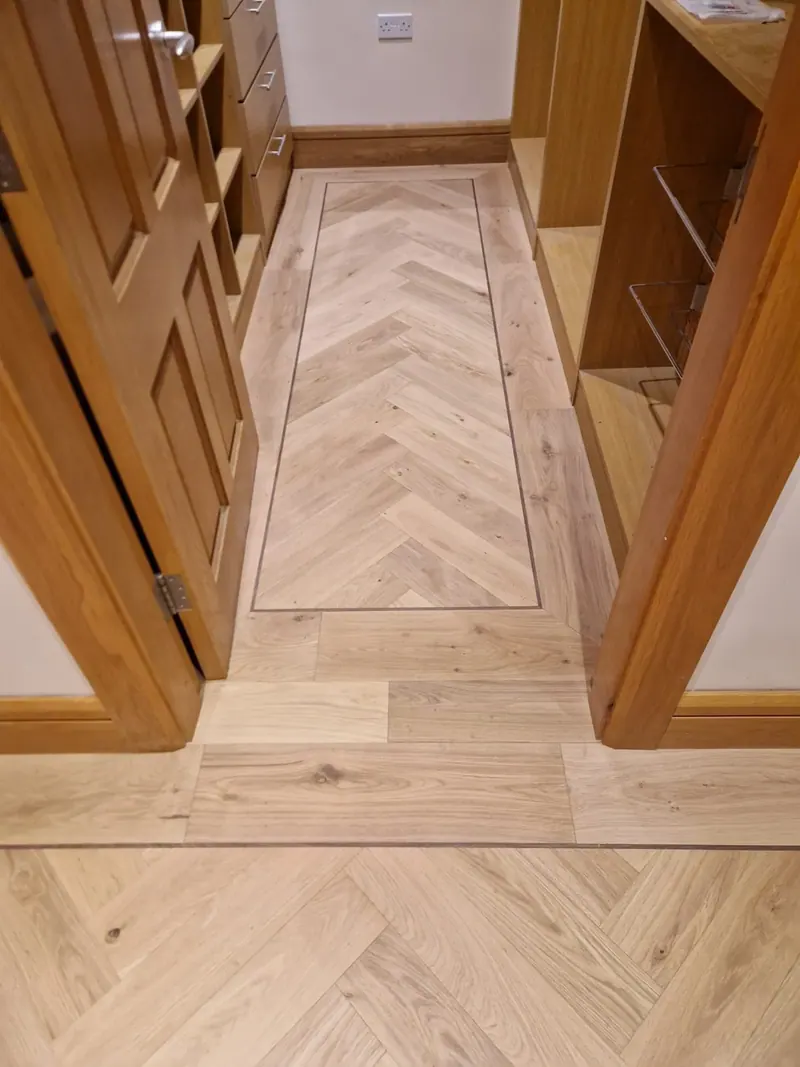 Herringbone hall floor with a border between solid oak doors