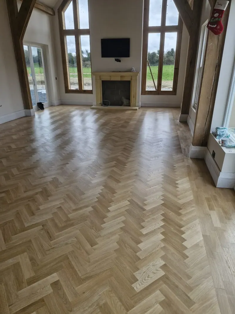 Herringbone floor in a large vaulted living room with a fireplace