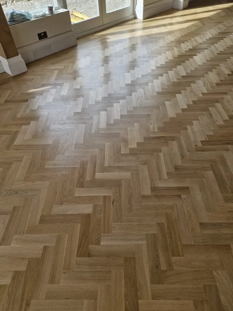 Glossy herringbone floor catching the afternoon light