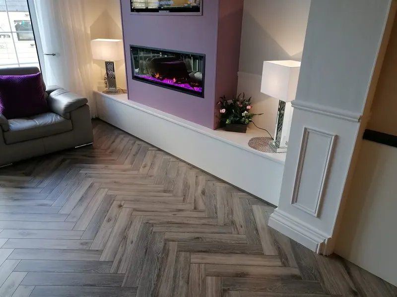 Grey herringbone floor meeting a feature fireplace wall