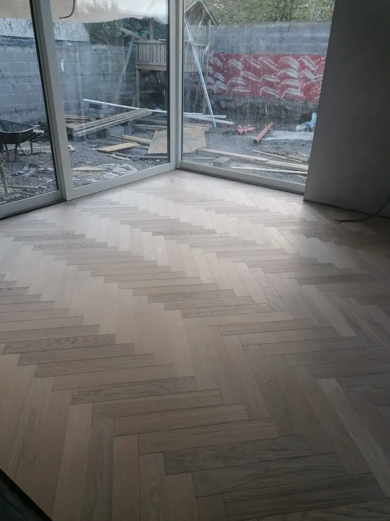 Grey herringbone floor laid up to full height patio doors